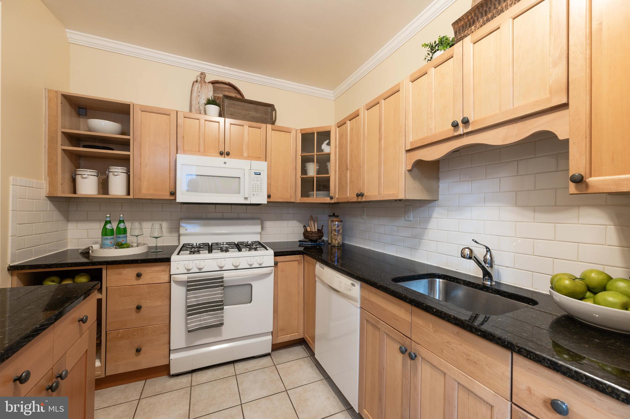 3 East Ostend Street Baltimore, MD 21230 - Photo 14 of 25 a kitchen with stainless steel appliances granite countertop white cabinets a stove a sink and dishwasher