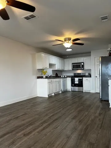 a view of a kitchen with a sink cabinets and stainless steel appliances