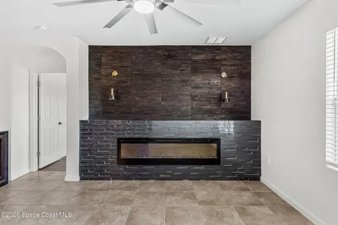 a view of a livingroom with a fireplace and a ceiling fan