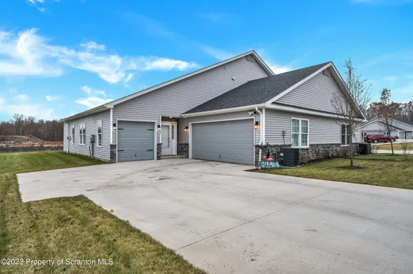 a view of a house with a big yard and large trees