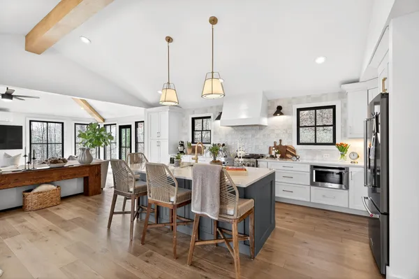 a view of a dining room and livingroom with furniture wooden floor a chandelier