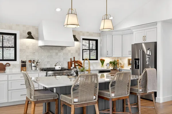 a kitchen with stainless steel appliances kitchen island granite countertop a dining table and chairs