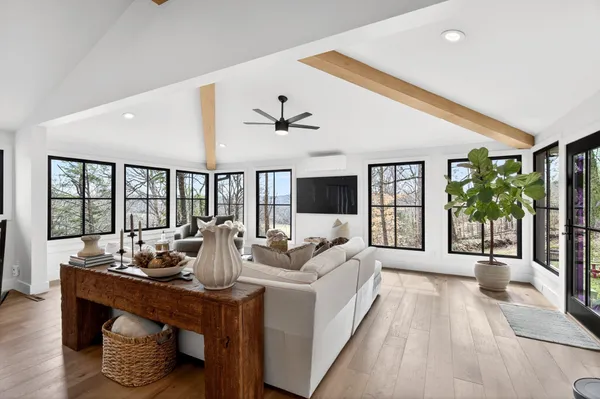 a living room with furniture large window and a table