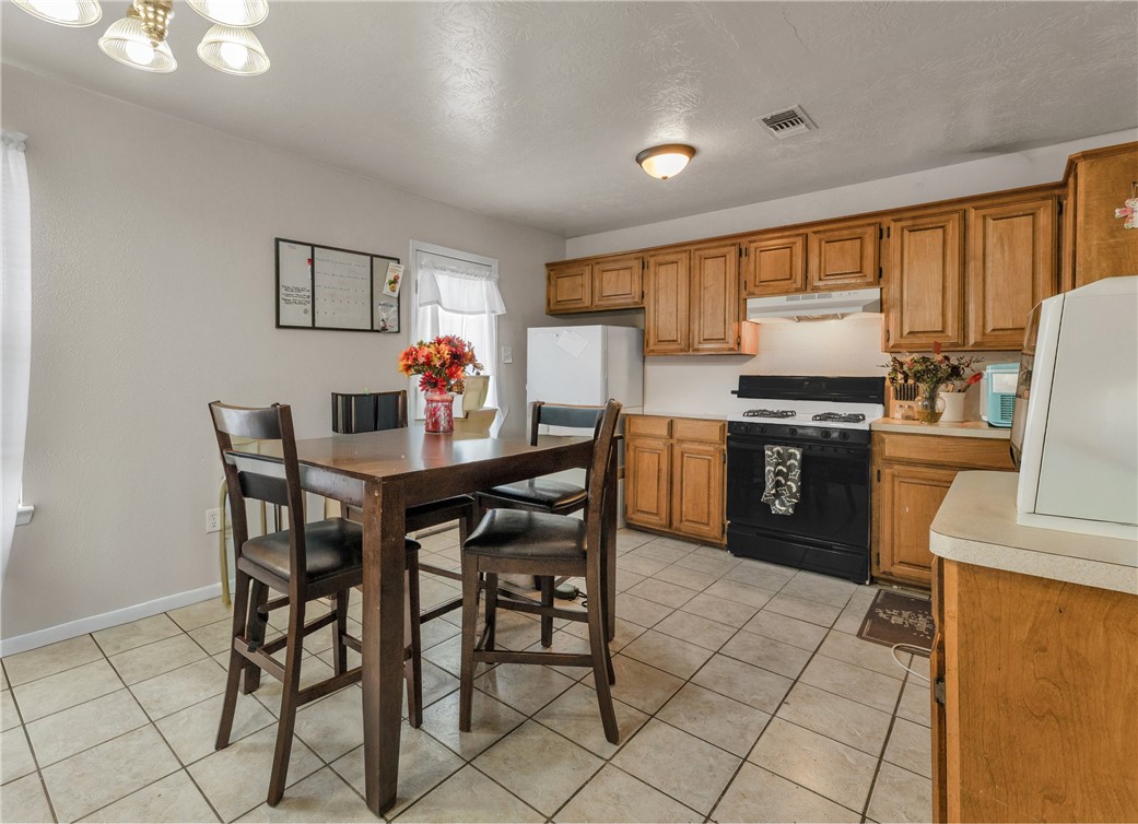 1011 West 17th Street Bryan, TX 77803 - Photo 4 of 6 a kitchen with stainless steel appliances a stove a table and chairs
