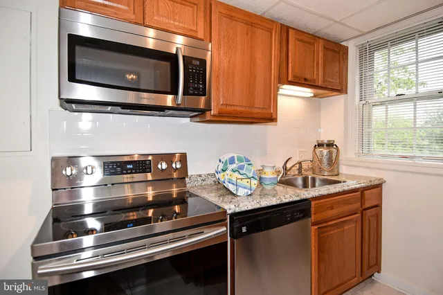 a kitchen with stainless steel appliances a sink stove and microwave