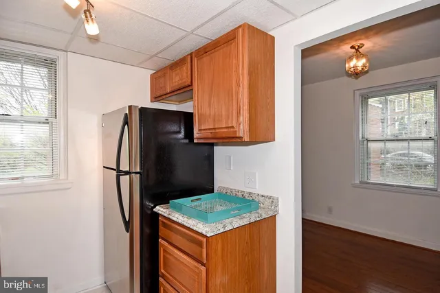 a kitchen with stainless steel appliances granite countertop a refrigerator a stove a sink and a window