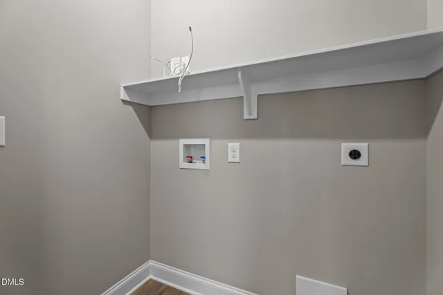 a view of an empty room with wooden floor and windows