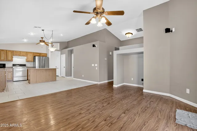 a view of a livingroom with a ceiling fan a kitchen space a ceiling fan and kitchen view
