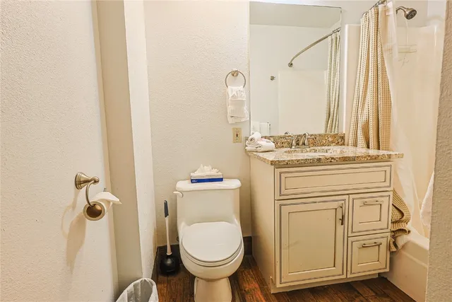 a bathroom with a granite countertop toilet sink and mirror