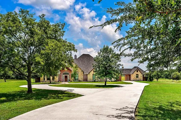 a view of a house with a big yard and large trees