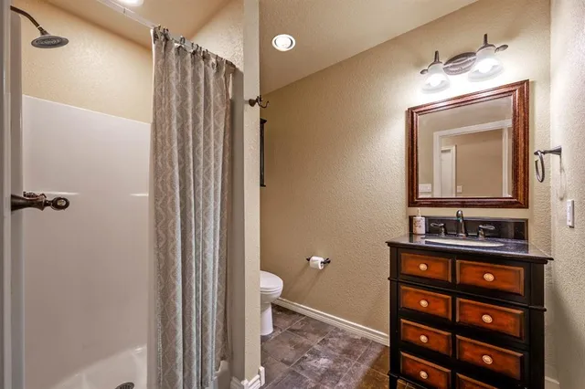 a bathroom with a toilet a sink and mirror