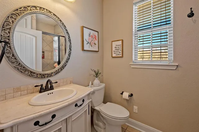 a bathroom with a toilet a sink and mirror