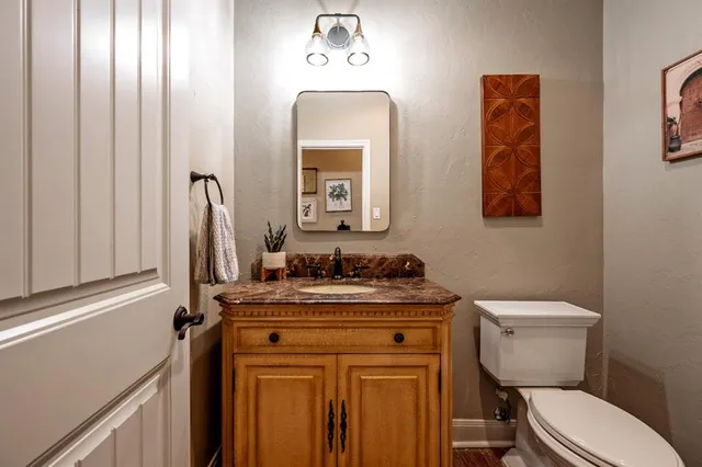 a bathroom with a toilet a sink and mirror