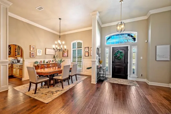 a dining room with furniture a chandelier and wooden floor