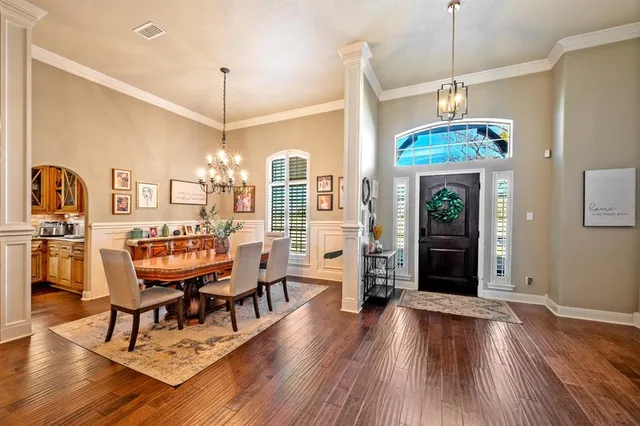 a dining room with furniture a chandelier and wooden floor