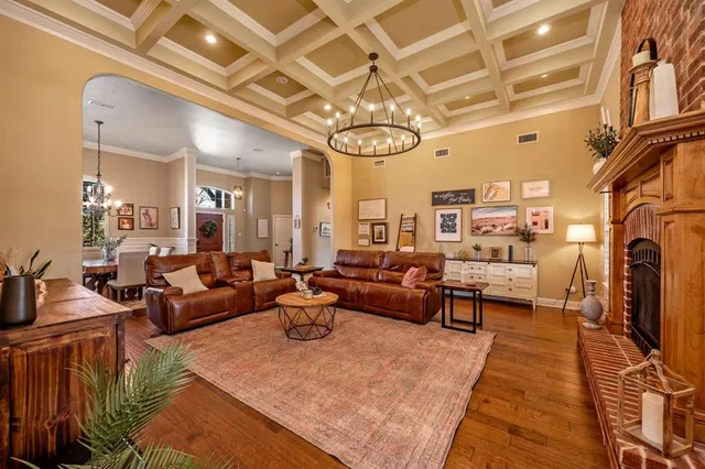 a living room with fireplace furniture and a chandelier