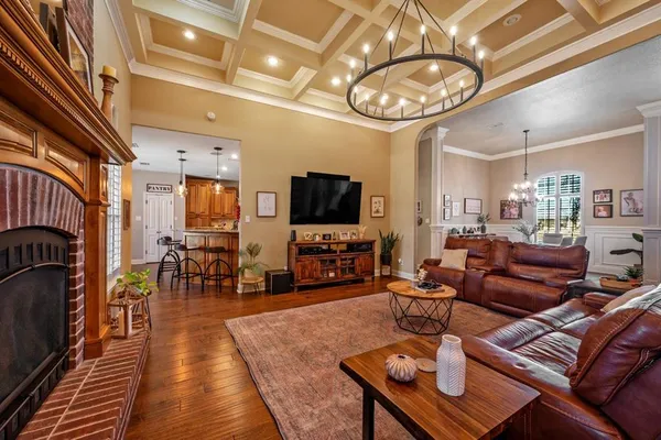 a living room with furniture a dining table and a chandelier