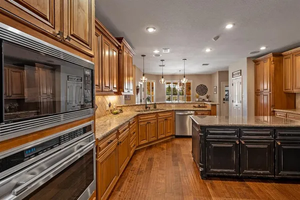 a kitchen with stainless steel appliances granite countertop a stove and a sink