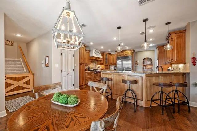 a dining room filled chandelier and wooden floor