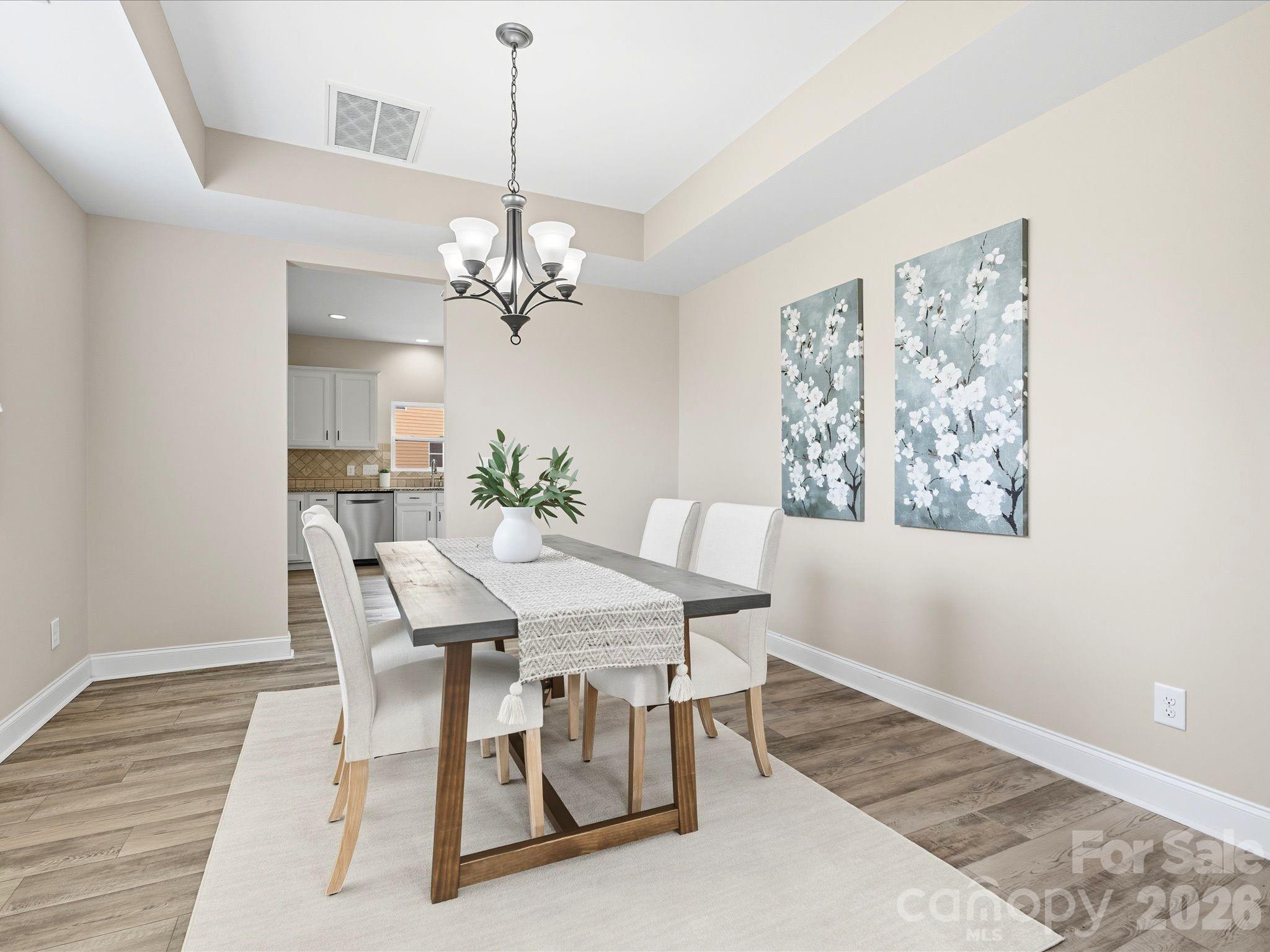 7196 Dove Field Lane Fort Mill, SC 29707 - Photo 4 of 35 a view of a dining room with furniture wooden floor and a chandelier
