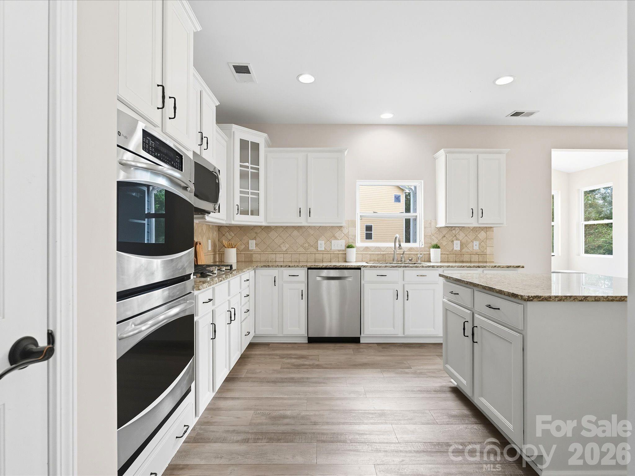 7196 Dove Field Lane Fort Mill, SC 29707 - Photo 6 of 35 a kitchen with granite countertop cabinets stainless steel appliances and a counter space