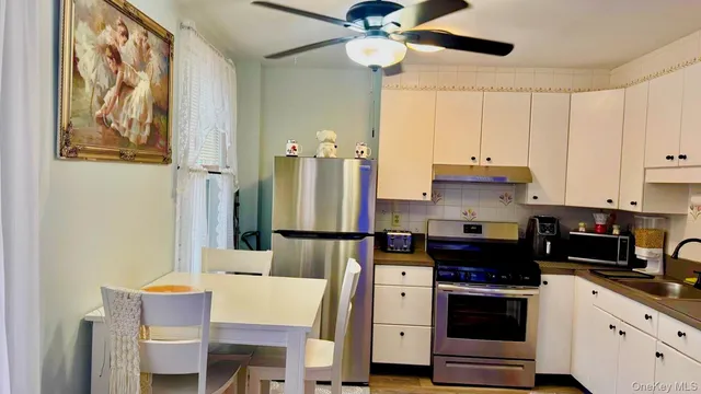 a kitchen with stainless steel appliances a stove refrigerator and cabinets