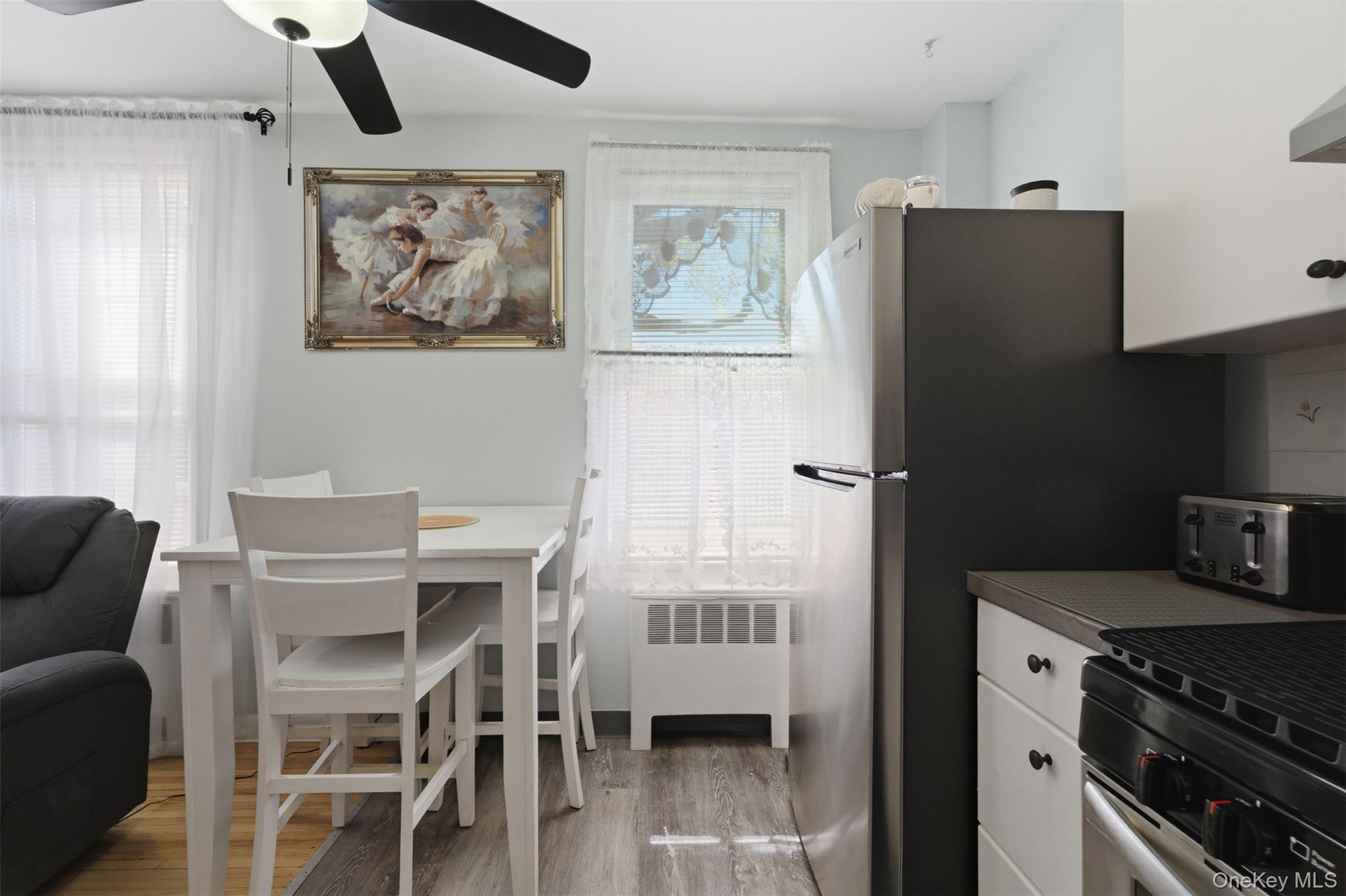 25 Trinity Place, Unit 2K New Rochelle, NY 10805 - Photo 8 of 24 The unit features a kitchen area with white cabinetry, a stainless steel refrigerator, and a gas range