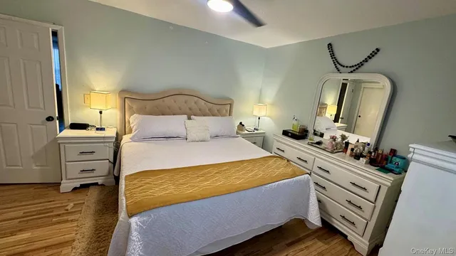 a bedroom with a bed and dresser with mirror