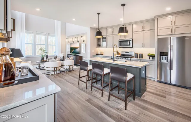 a large kitchen with a table chairs refrigerator and cabinets