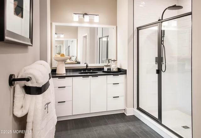 a bathroom with a double vanity sink a mirror and shower