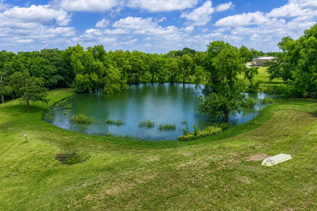 900 Hodgins Road Van Alstyne, TX 75495 - Photo 10 of 10 Expansive grassy grounds featuring a private pond surrounded by mature trees