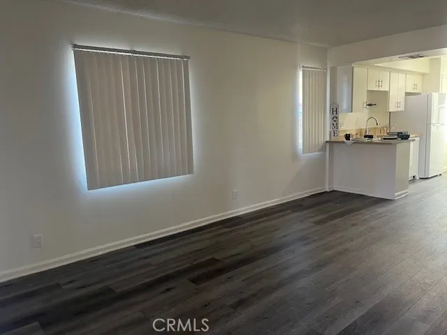a view of a kitchen with wooden floor and cabinets