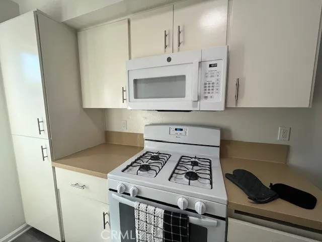 a white stove top oven sitting inside of a kitchen