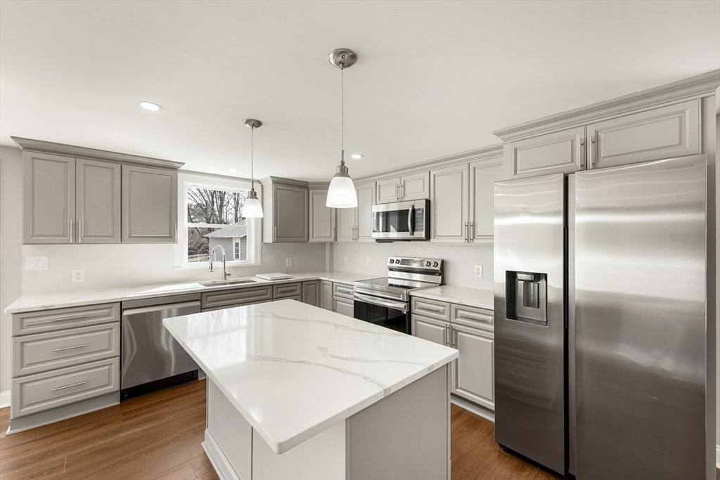 26 Maple Street Mendon, MA 01756 - Photo 2 of 42 a kitchen with white cabinets and stainless steel appliances