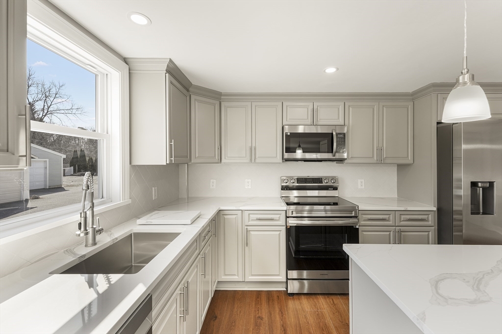 26 Maple Street Mendon, MA 01756 - Photo 5 of 42 a kitchen with granite countertop white cabinets and black stainless steel appliances