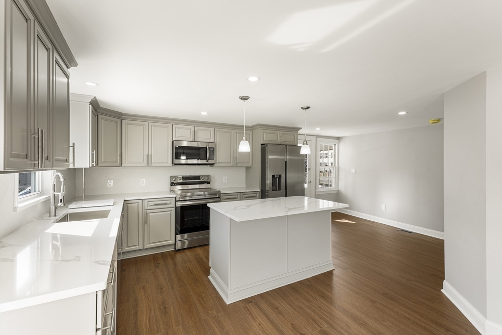 26 Maple Street Mendon, MA 01756 - Photo 6 of 42 a large kitchen with cabinets wooden floor and stainless steel appliances
