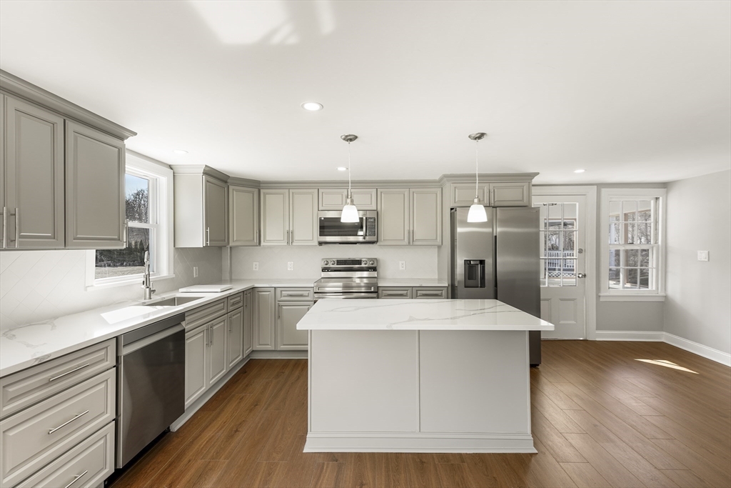 26 Maple Street Mendon, MA 01756 - Photo 7 of 42 a large kitchen with stainless steel appliances kitchen island a large counter top and wooden floors