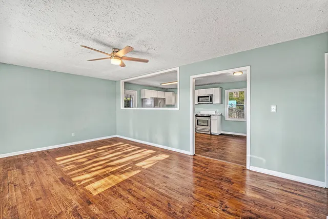 a bedroom with wooden floor and a ceiling fan