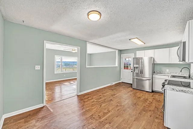 a kitchen with refrigerator cabinets and wooden floor