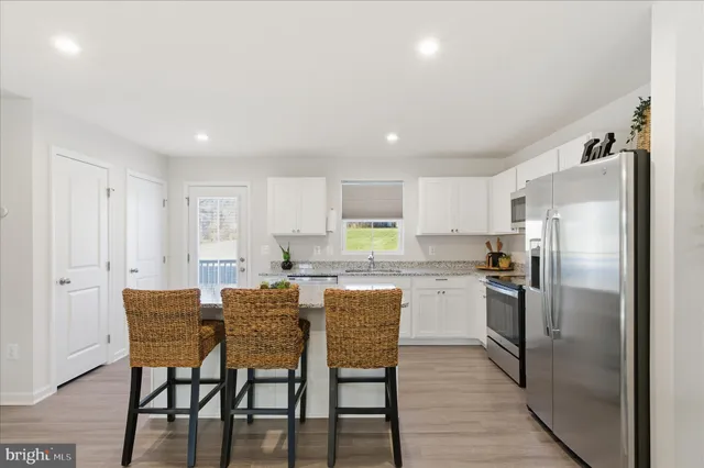 a kitchen with a dining table chairs refrigerator and cabinets