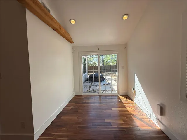 a view of a hallway with wooden floor and furniture