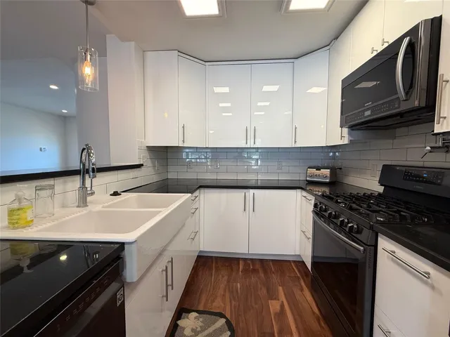 a kitchen with stainless steel appliances a sink stove and cabinets