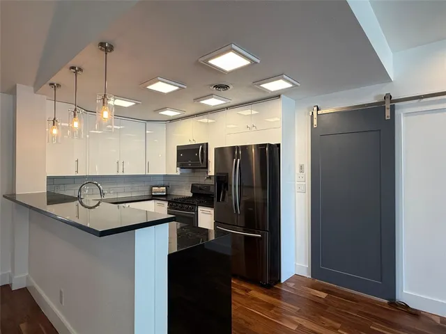 a kitchen with stainless steel appliances granite countertop a refrigerator a sink and a refrigerator