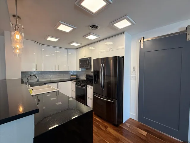 a kitchen with stainless steel appliances granite countertop a refrigerator and a sink