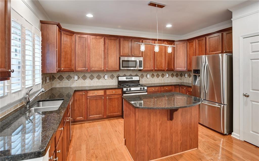 2804 Loftview Square, Unit 3 Atlanta, GA 30339 - Photo 11 of 36 a kitchen with stainless steel appliances granite countertop a refrigerator a sink a stove top oven a large window with wooden floor and cabinets