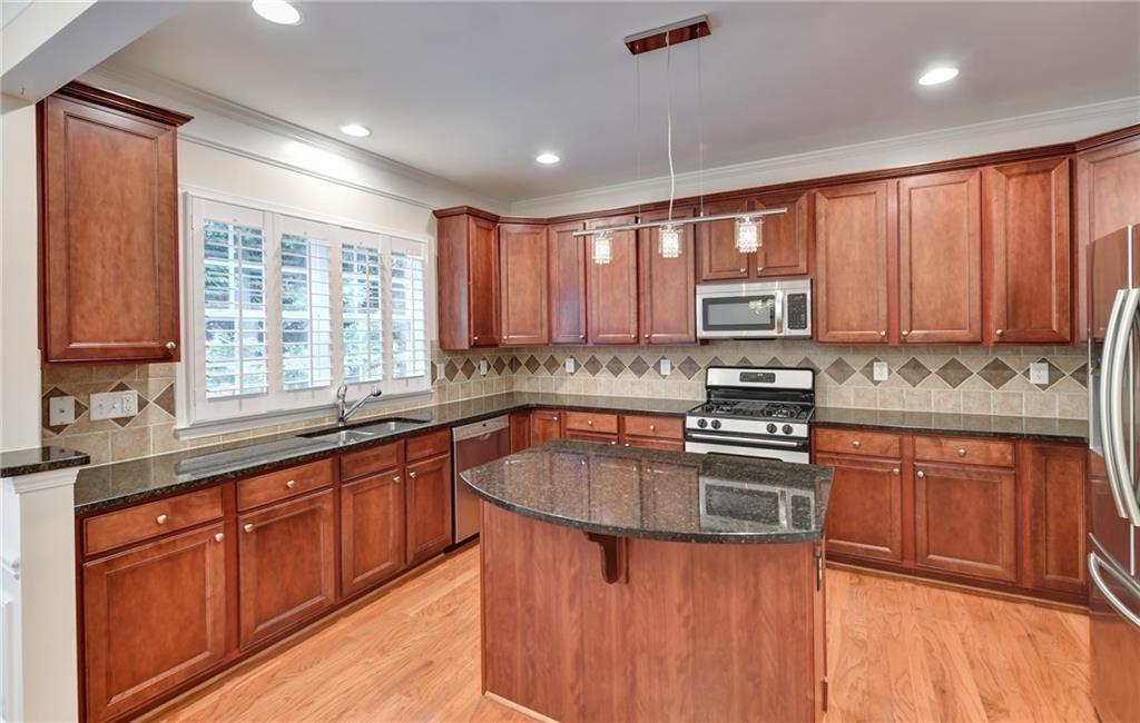 2804 Loftview Square, Unit 3 Atlanta, GA 30339 - Photo 12 of 36 a kitchen with stainless steel appliances granite countertop wooden cabinets sink and a granite counter top