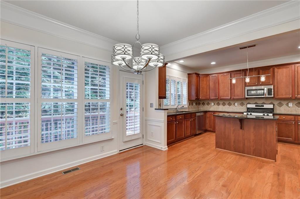 2804 Loftview Square, Unit 3 Atlanta, GA 30339 - Photo 13 of 36 a large kitchen with stainless steel appliances granite countertop a stove a sink dishwasher a microwave oven with cabinets and wooden floor