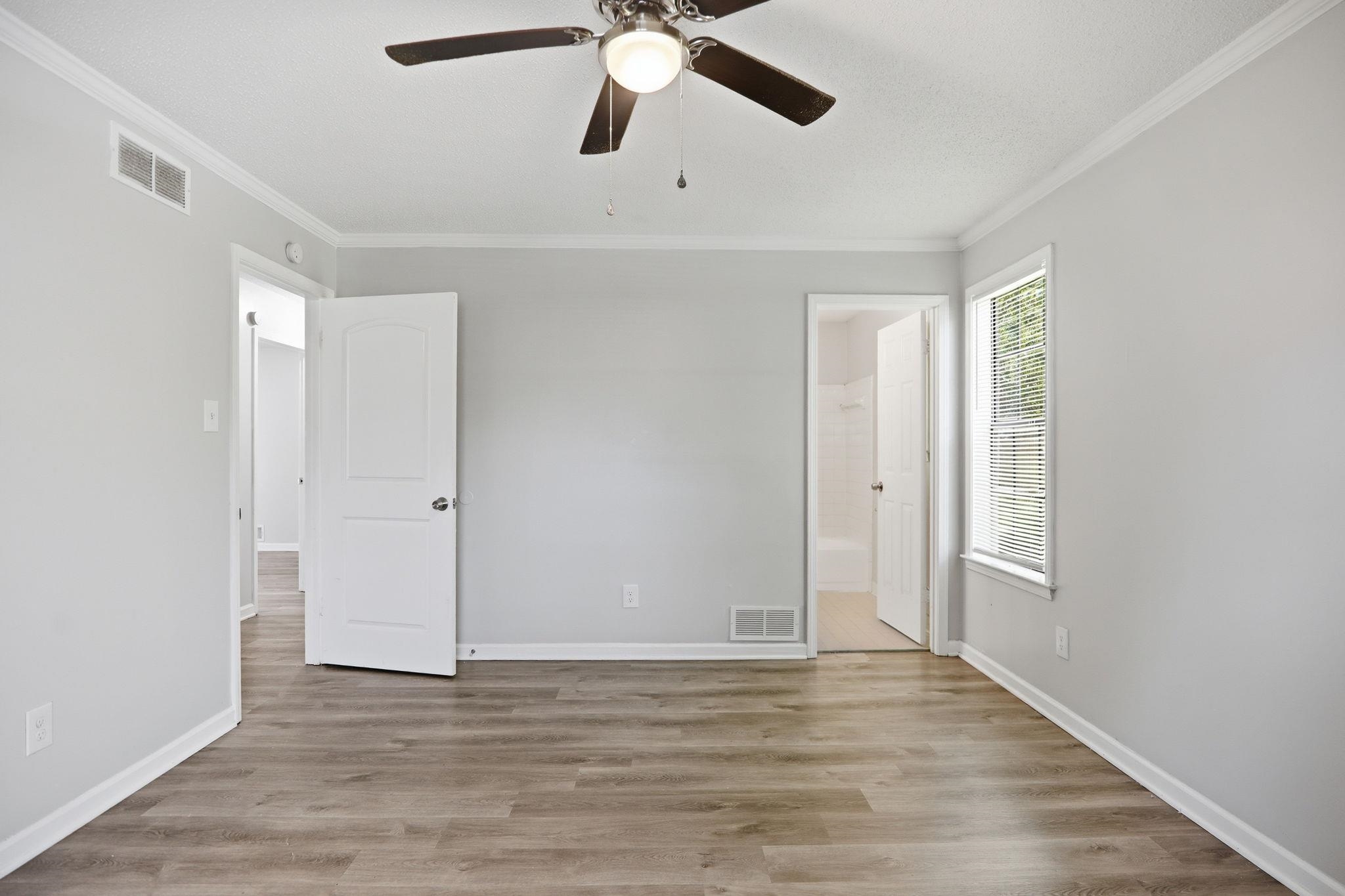 3113 Raleigh Ridge Cove Memphis, TN 38128 - Photo 23 of 38 Spacious room featuring wood-finish flooring, light grey painted walls, white crown molding, and a ceiling fan with integrated lighting