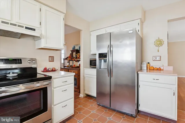a kitchen with cabinets stainless steel appliances and a counter space
