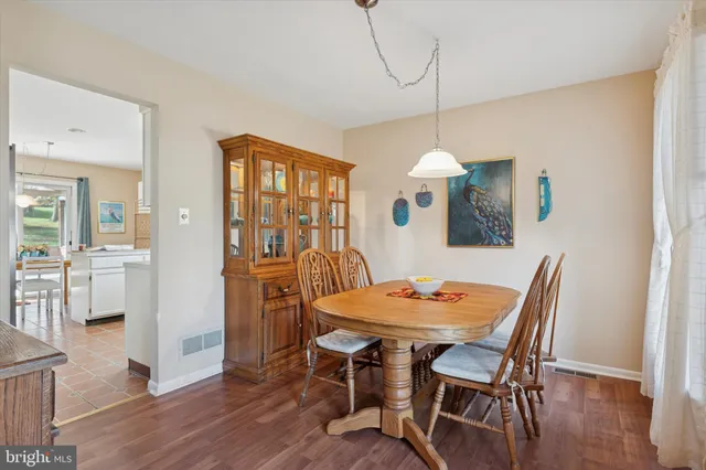 a dining room with furniture a chandelier and wooden floor